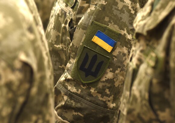 A Ukrainian flag patch and trident on a soldier's uniform