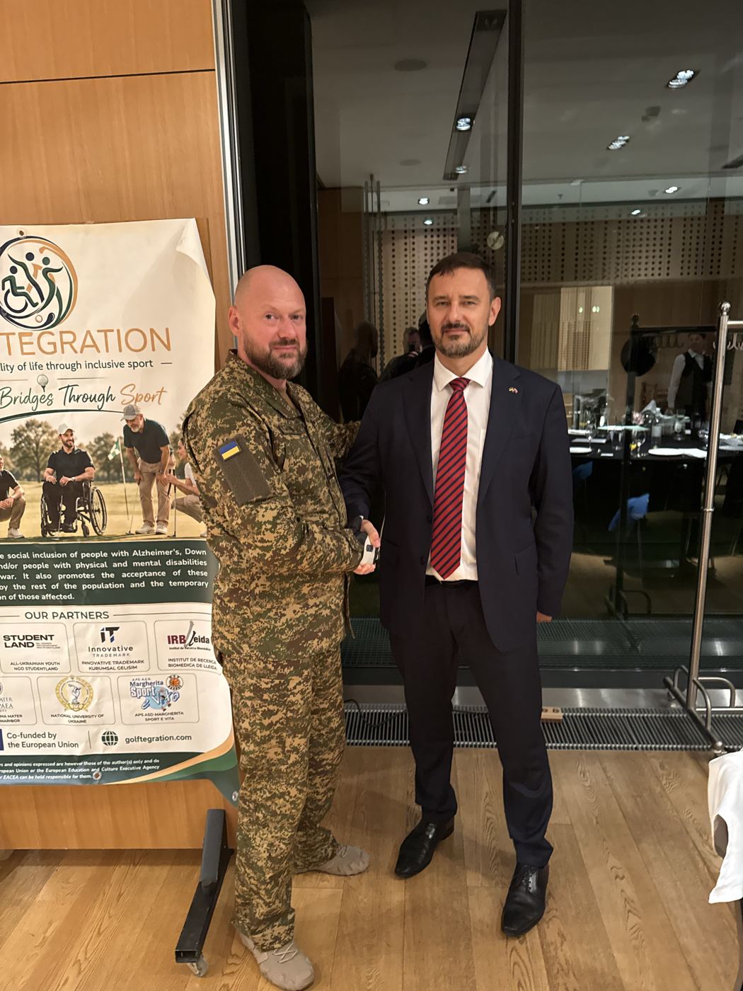 A Ukrainian veteran meets a guest at the Golftegration stand