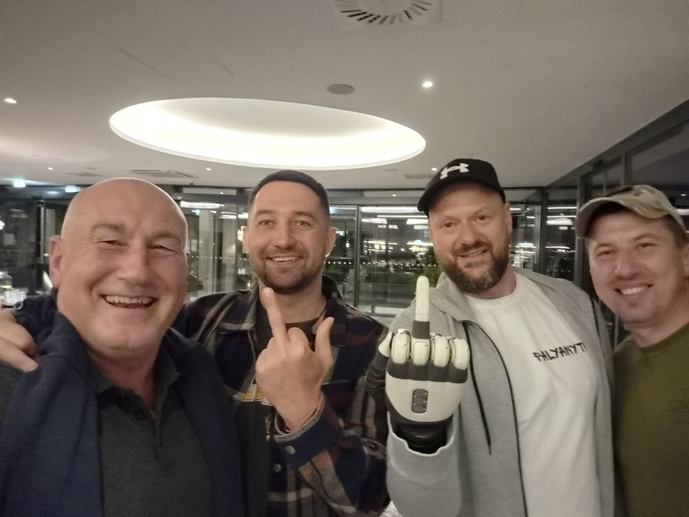Ukrainian veterans and members of the delegation together in Slovenia; one veteran shows his prosthetic hand